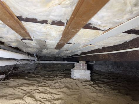 Schema van een kruipruimte met isolatiemateriaal, leidingen en een kruipluik