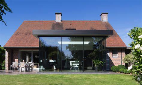 Voorbeeld van een gerenoveerde woonboerderij met grote glazen vlakken