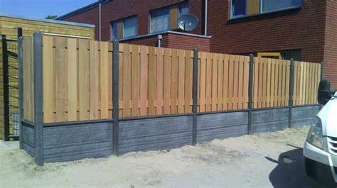 Foto: voorbeeld van een hout-betonschutting met poort en betonnen onderplaat