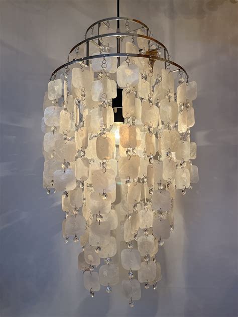 Illustratie van de montage van een Capiz schelpen lamp aan het plafond, met details over de plafondfitting en bevestigingspunten.