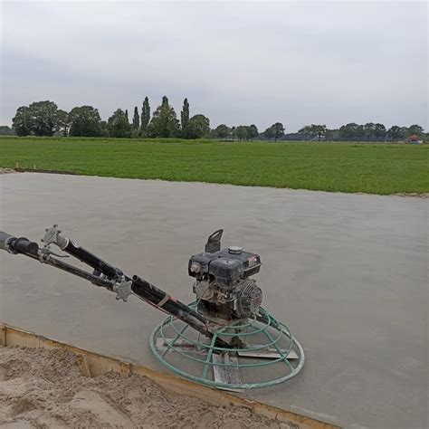 een vlindermachine die wordt gebruikt om een betonvloer af te werken, met focus op de gladde afwerking