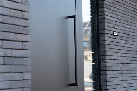 Foto van een moderne voordeur met een strakke RVS deurgreep.