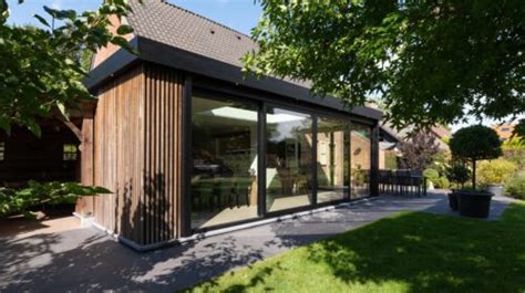 Voorbeeld van een moderne houten aanbouw met grote glazen pui
