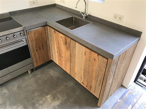 Display foto van teak-achtige houten fronten naast betonnen blad