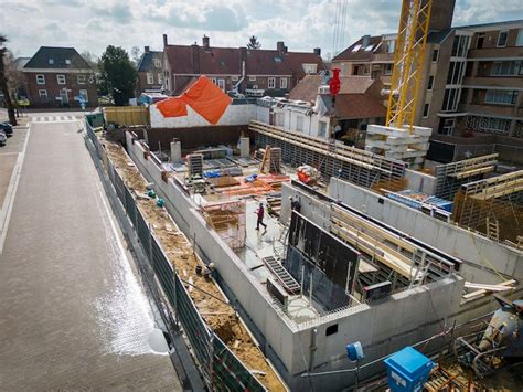 Illustratie van een bouwlocatie met heiwerkzaamheden en huizen op de achtergrond.