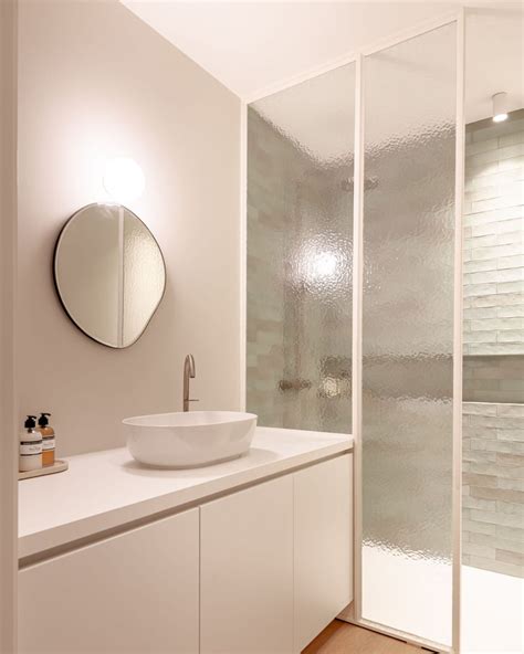 Een moderne badkamer met strakke lijnen, minimalistisch design en hoogwaardige materialen zoals chroom en glas.
