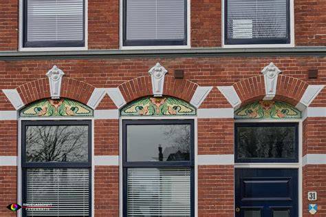 Gevelbetegeling met tegeltableaus en sectietegels
