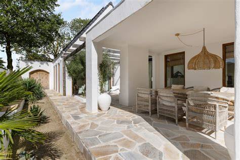 Ibiza stijl buitenruimte met flagstones, schelpenpaden en witte shutters