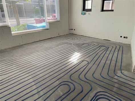 Illustratie van een huis met onder de vloer zichtbare verwarmingsbuizen.