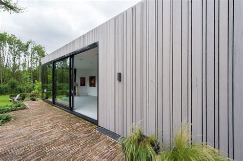 Illustratie van een huis met verticale gevelbekleding die de woning optisch hoger doet lijken.