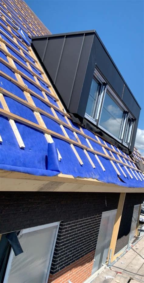 Voorbeeld van hoogwaardig zinkwerk op een dak en gevel