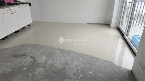 Illustratie van een persoon die egaline aanbrengt op een balkonvloer met een vloeitrekker.