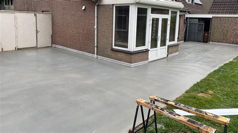 Gedetailleerde foto van het voorbereiden van een betonnen garagevloer, met schuren en reinigen.