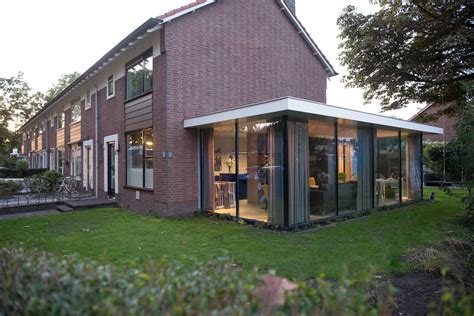 Foto van een gerenoveerde jaren '50 woning met moderne uitbouw en gevelbekleding