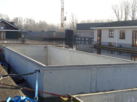 Grote betonnen bak voor een woonark, met afmeerpontons