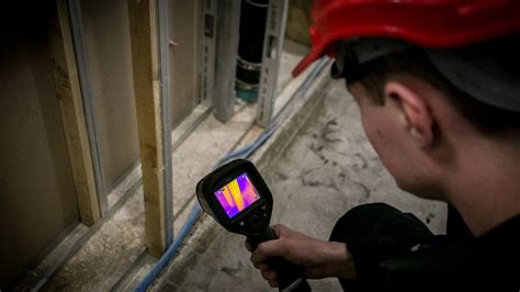 Illustratie van een lekdetectiespecialist die met een infraroodcamera een muur scant