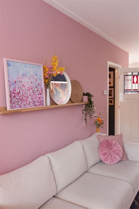 Een sfeervolle foto van een woonkamer met het roze geometrische vliesbehang op de muur.