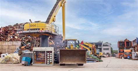 Foto van een moderne metaalrecycling faciliteit met vrachtwagens en stapels metaalschroot