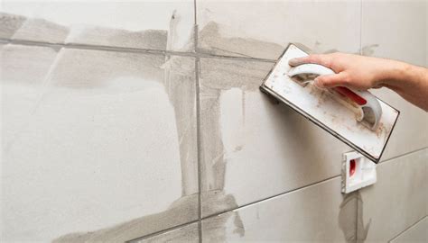 Illustratie van een badkamerwand voor en na het stucen over tegels