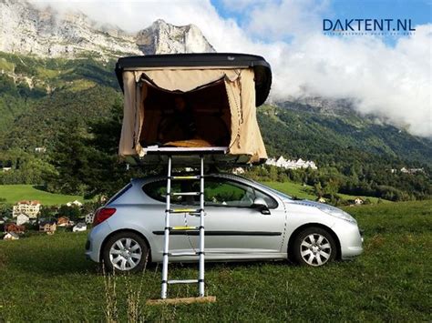 Close-up van een iKamper Skycamp daktent, met de deuren open, die een comfortabele slaapplek suggereert.