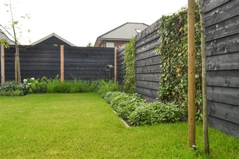 Voorbeeld van een moderne tuin met zwarte schutting schermen en betonnen palen