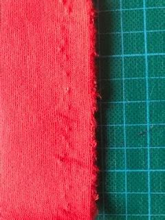 Voorbeeld van een strookje stof met tekst van de zelfkant, gebruikt voor afwerking.