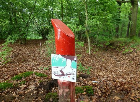 Detail van een historisch betonnen paaltje met markeringen in het bos