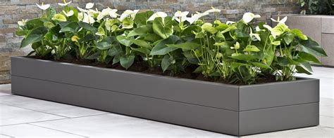 Afbeelding van een betonnen bloembak die wordt behandeld met een waterdichtingsmiddel