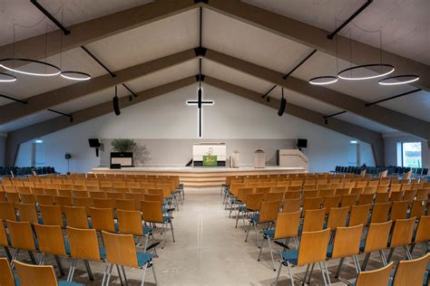Interieurfoto van de vernieuwde kerkzaal met nieuwe vloer, stoelen en lichte plafondafwerking